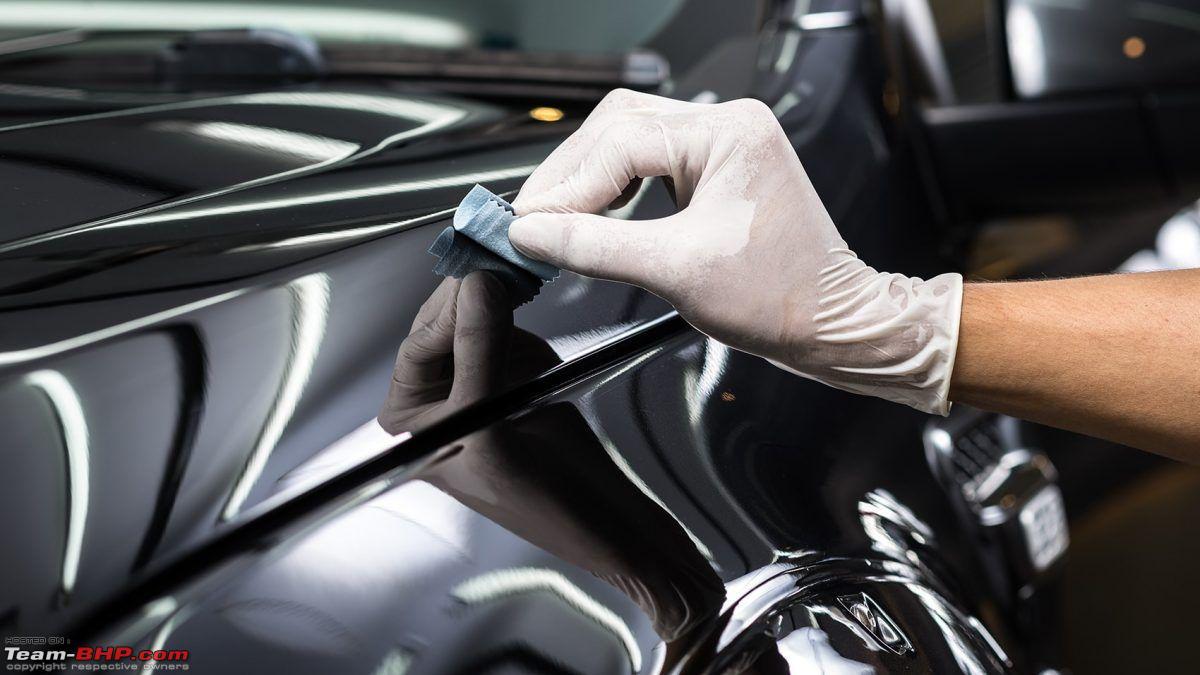 Applying paint protection coating on luxury black car surface
