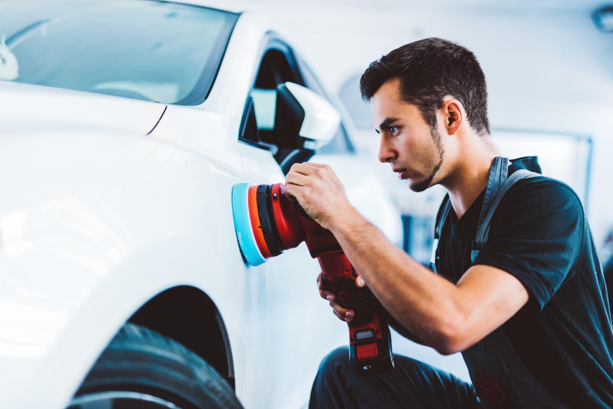 Technician polishing luxury car paint at ZY Thor Car Detailing Center